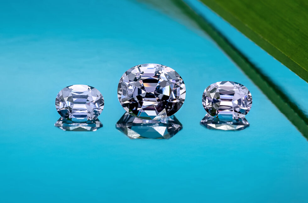 Three oval-cut grey spinels in varying sizes, with the middle one being the largest