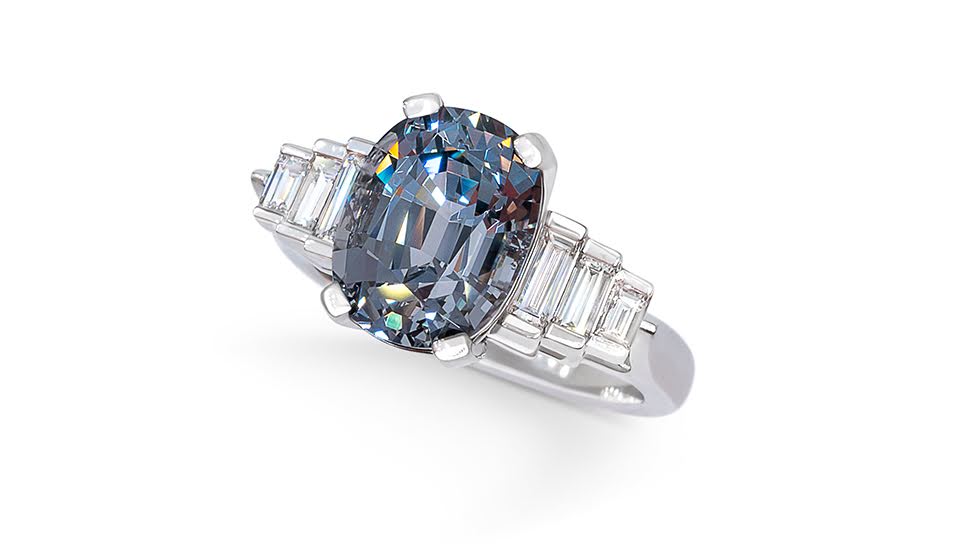 Oval grey spinel flanked by Cadillac diamonds of varying sizes on each side